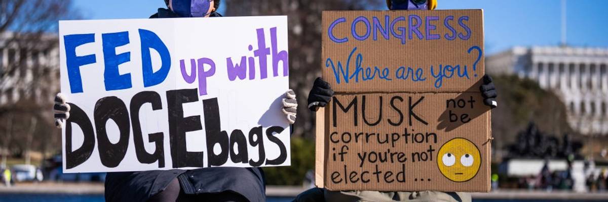 Demonstrators hold signs during a protest
