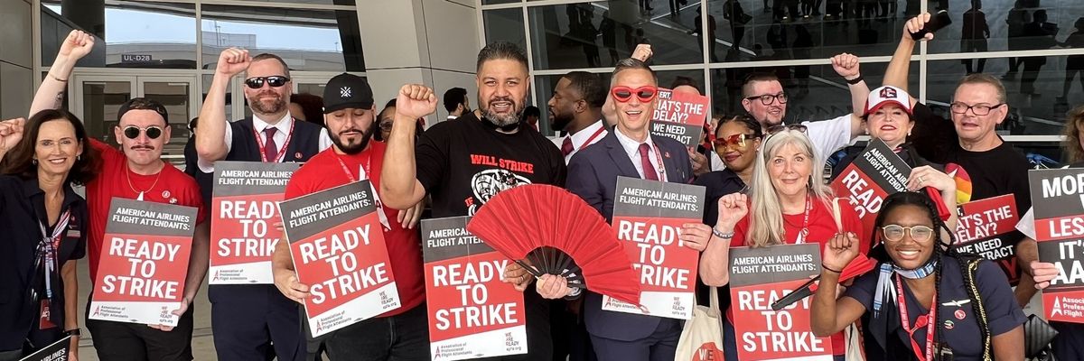 Demonstrators hold signs showing that flight attendants are "ready to strike."