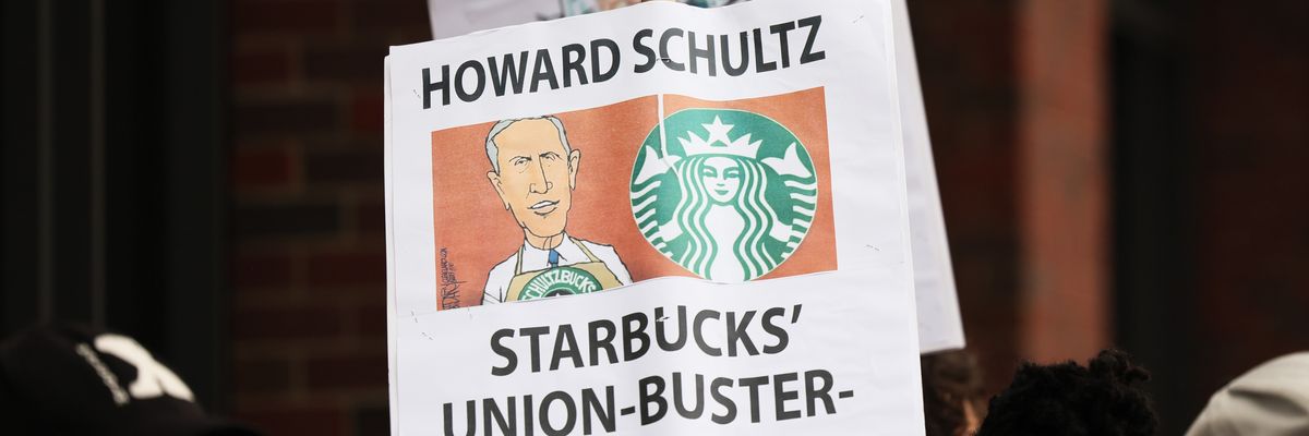 Demonstrators hold signs while protesting in front of a Starbucks shop on April 14, 2022 in New York City. ​