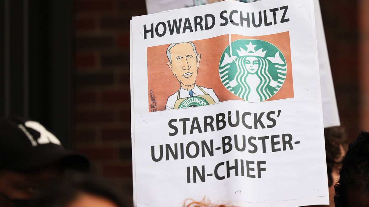 Demonstrators hold signs while protesting in front of a Starbucks shop on April 14, 2022 in New York City. 