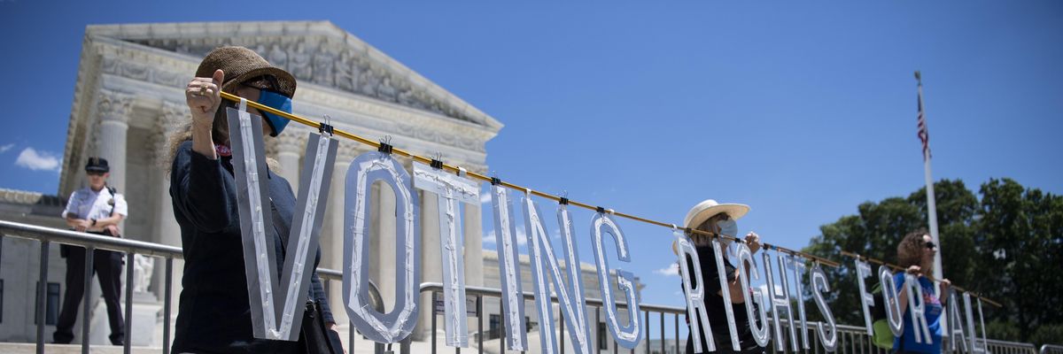 Demonstrators hold up a sign