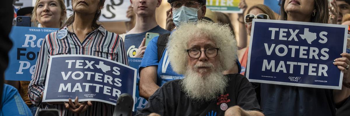 Demonstrators hold up signs at a rally at the Texas State Capitol on June 20, 2021 in Austin.