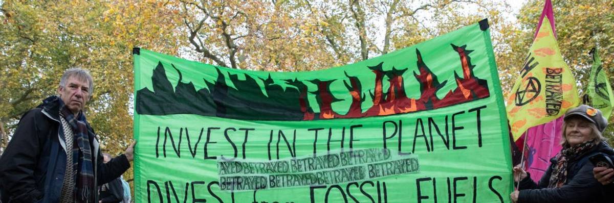 Demonstrators holding sign that reads: "Invest in the planet / Divest from Fossil Fuels"