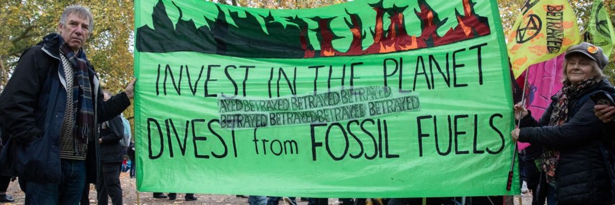Demonstrators holding sign that reads: "Invest in the planet / Divest from Fossil Fuels"