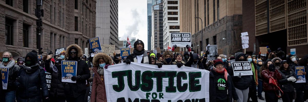 Demonstrators march behind a banner reading "Justice for Amir Locke and All Stolen Lives" during a rally in protest of the killing of Amir Locke, outside the Hennepin County Government Center in Minneapolis, Minnesota on February 5, 2022.