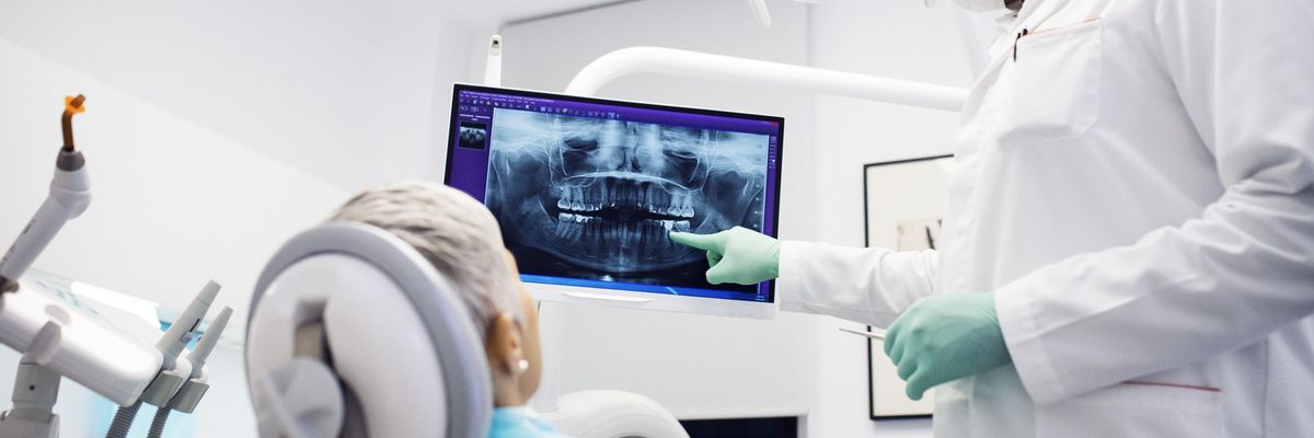 Dentist explaining x-ray to female patient at clinic