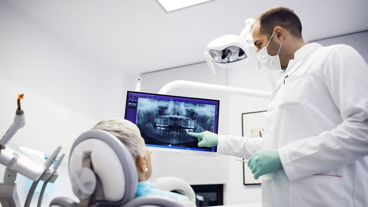 Dentist explaining x-ray to female patient at clinic