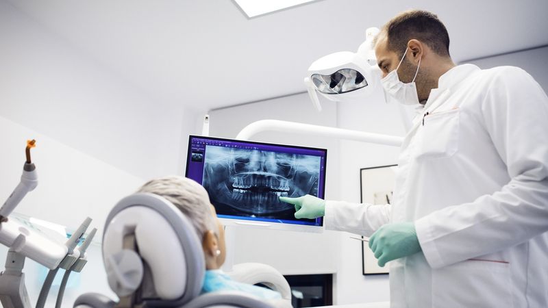 Dentist explaining x-ray to female patient at clinic