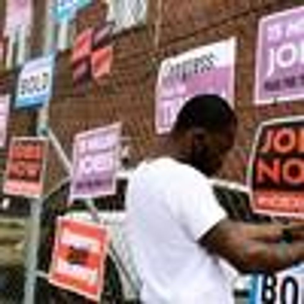 Derrick Davis, a member of West Virginia New Jobs Coalition, hangs up signage during a community gathering and job fair on April 8, 2021 in Charleston, West Virginia.