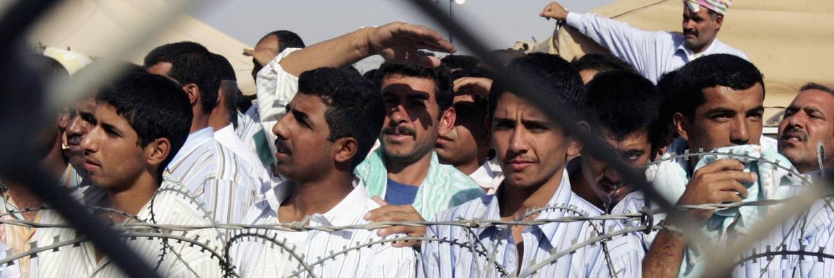Detainees stand in the Abu Ghraib prison yard while waiting to be released on June 27, 2006 in Baghdad, Iraq.