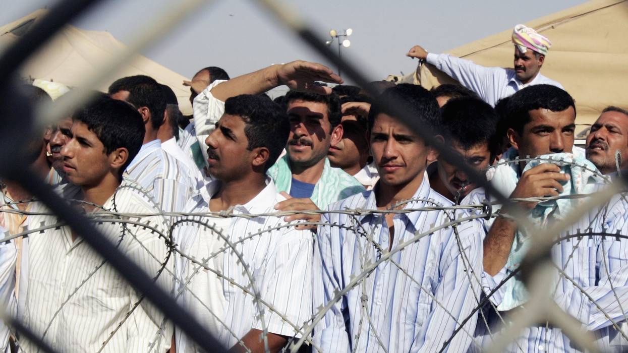 Detainees stand in the Abu Ghraib prison yard while waiting to be released on June 27, 2006 in Baghdad, Iraq.