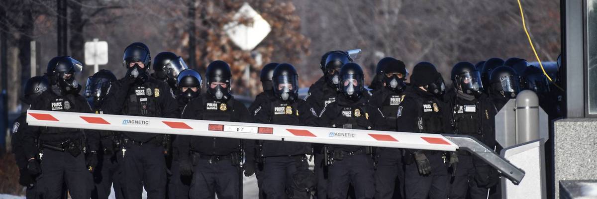 DHS officers line up outside a federal building.