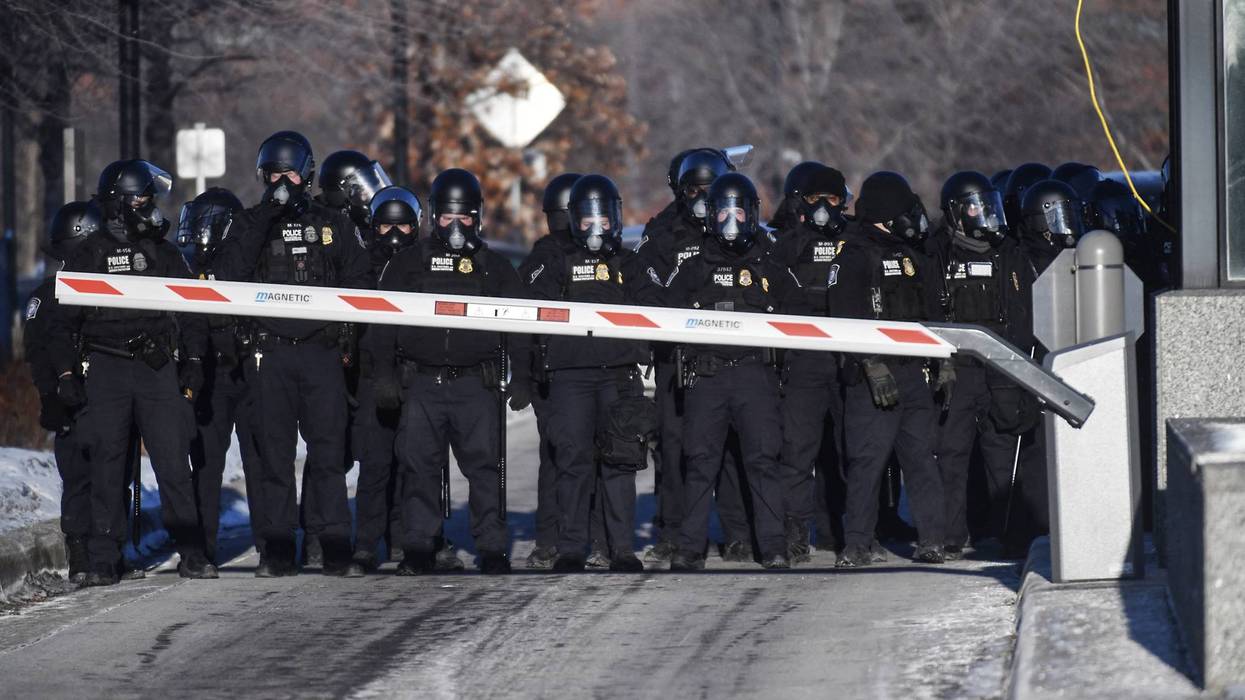 DHS officers line up outside a federal building.