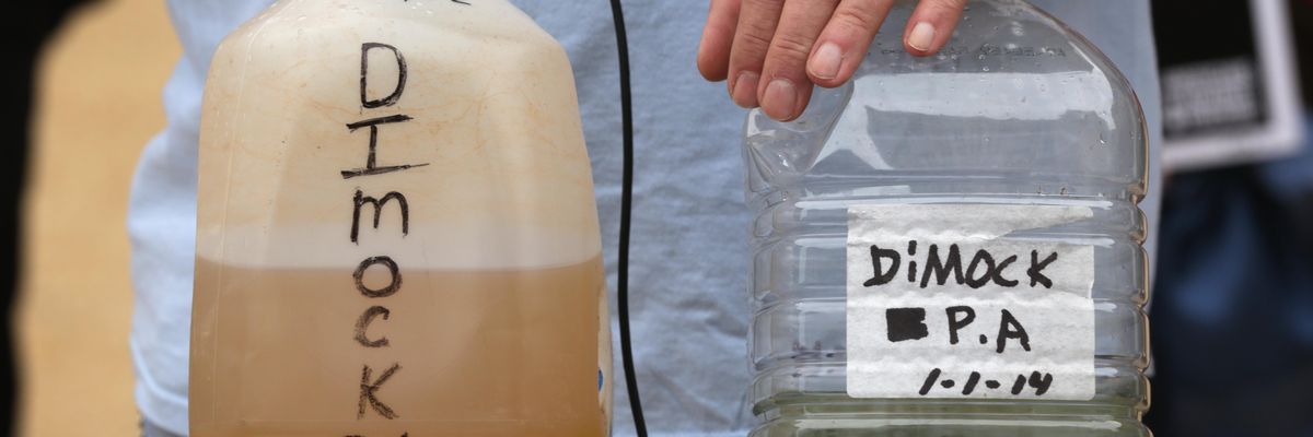Dimock, Pennsylvania resident Ray Kemble displays samples of contaminated water during an anti-fracking rally outside the headquarters of the U.S. Environmental Protection Agency in Washington, D.C. on October 10, 2014.