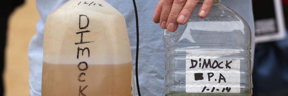 Dimock, Pennsylvania resident Ray Kemble displays samples of contaminated water during an anti-fracking rally outside the headquarters of the U.S. Environmental Protection Agency in Washington, D.C. on October 10, 2014.