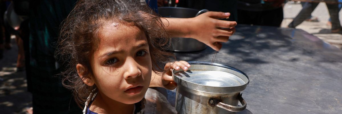 Displaced Palestinian children line up to receive food in Rafah