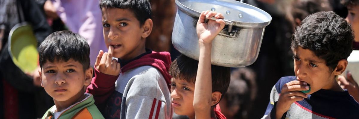Displaced Palestinian children waiting in line for food assistance in central Gaza