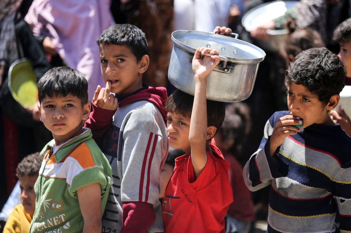 Displaced Palestinian children waiting in line for food assistance in central Gaza
