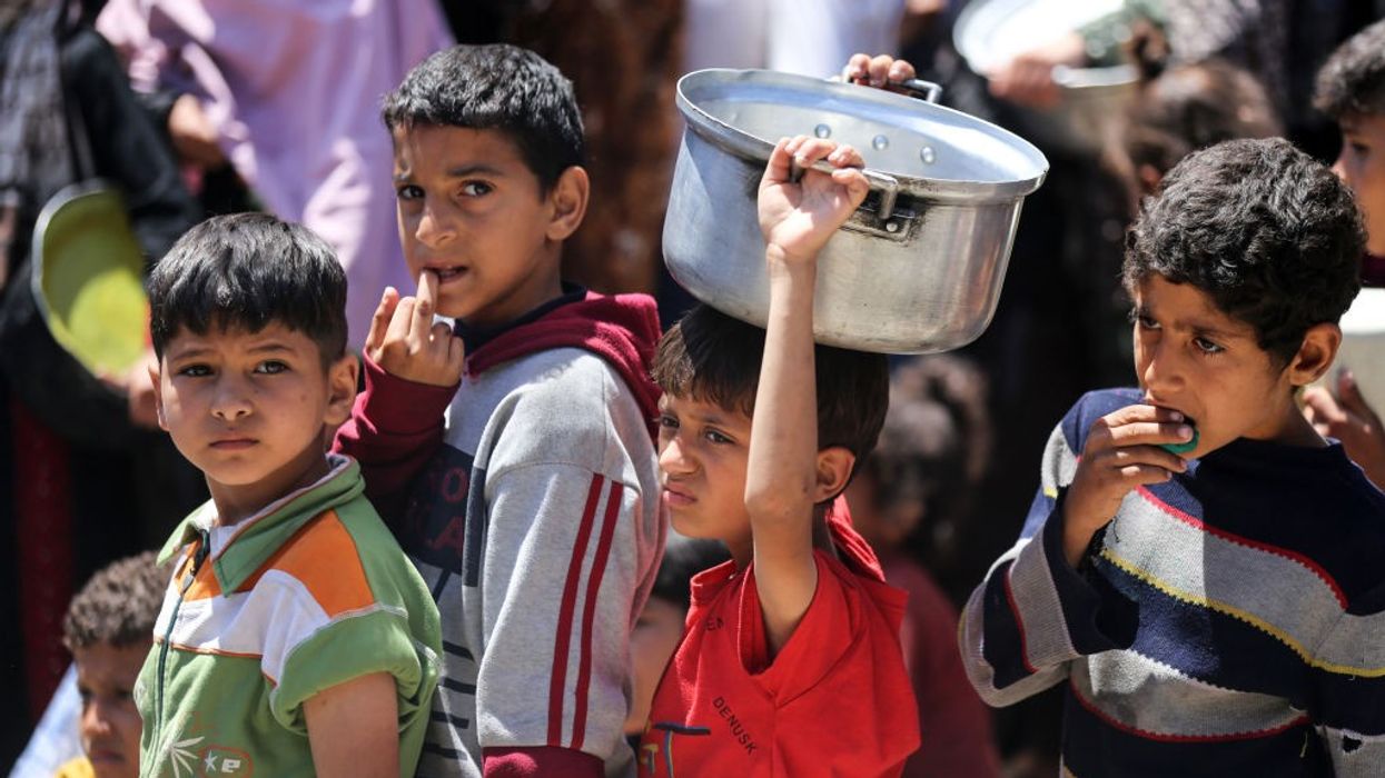 Displaced Palestinian children waiting in line for food assistance in central Gaza