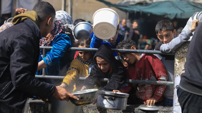 Displaced Palestinians gather to receive food in Rafah