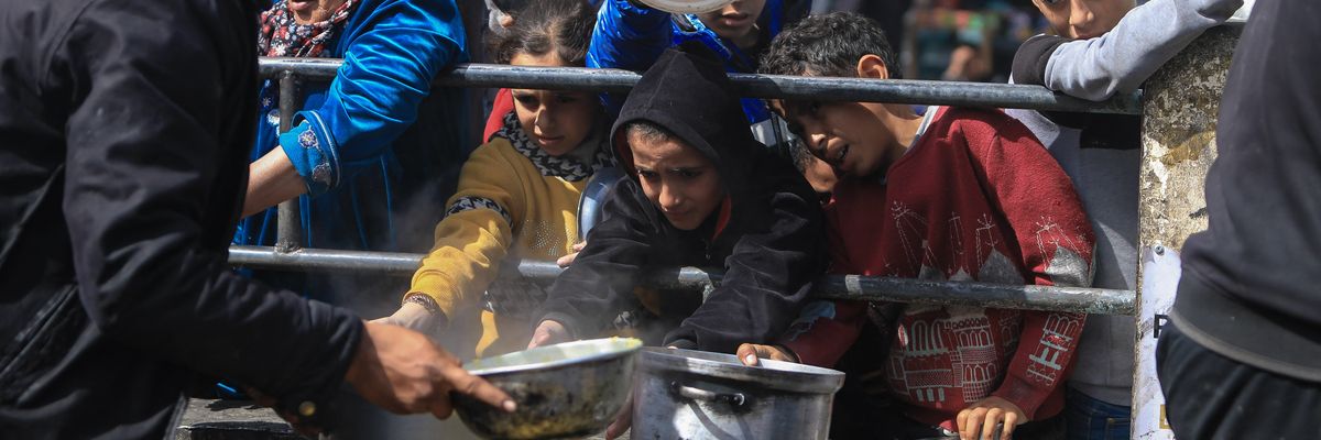 Displaced Palestinians gather to receive food in Rafah