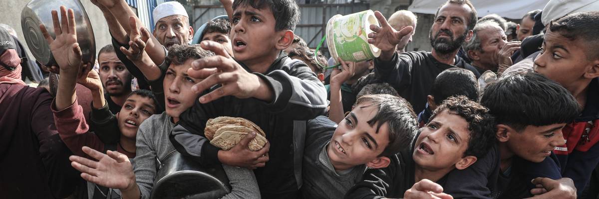 Displaced Palestinians receive food aid in Nuseirat Camp