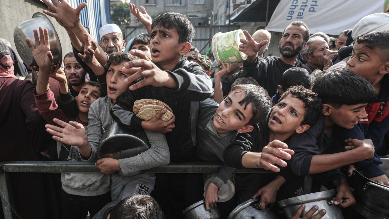 Displaced Palestinians receive food aid in Nuseirat Camp