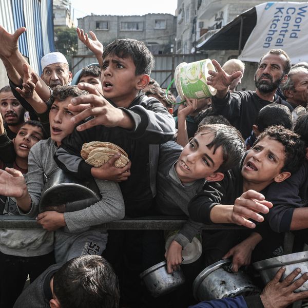 Displaced Palestinians receive food aid in Nuseirat Camp