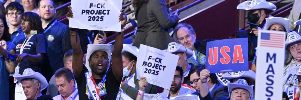 DNC attendees hold signs that say F*ck Project 2025
