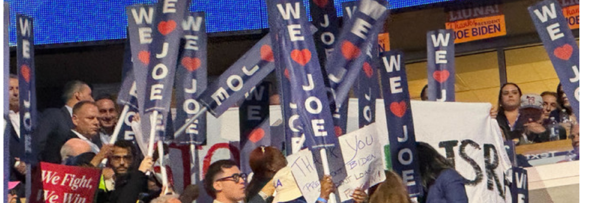 DNC delegates hold up "We Love Joe" signs to block Stop Arming Israel banner