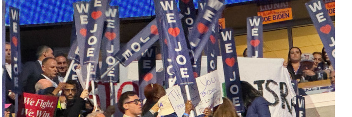 DNC delegates hold up "We Love Joe" signs to block Stop Arming Israel banner