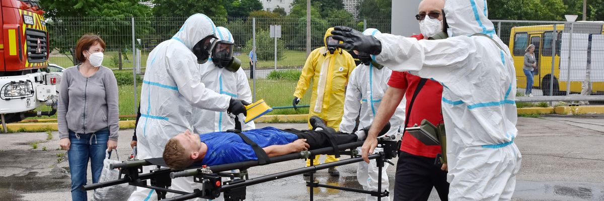 Doctors in protection suits check radiation level of bus passengers
