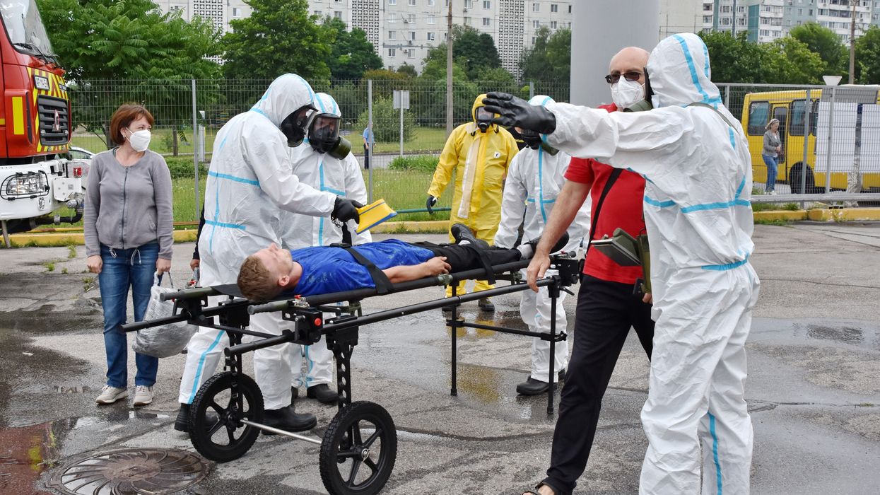 Doctors in protection suits check radiation level of bus passengers