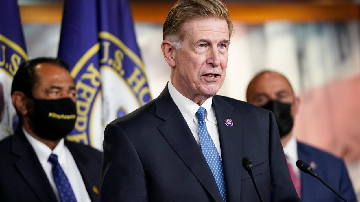 Don Beyer stands in a suit.