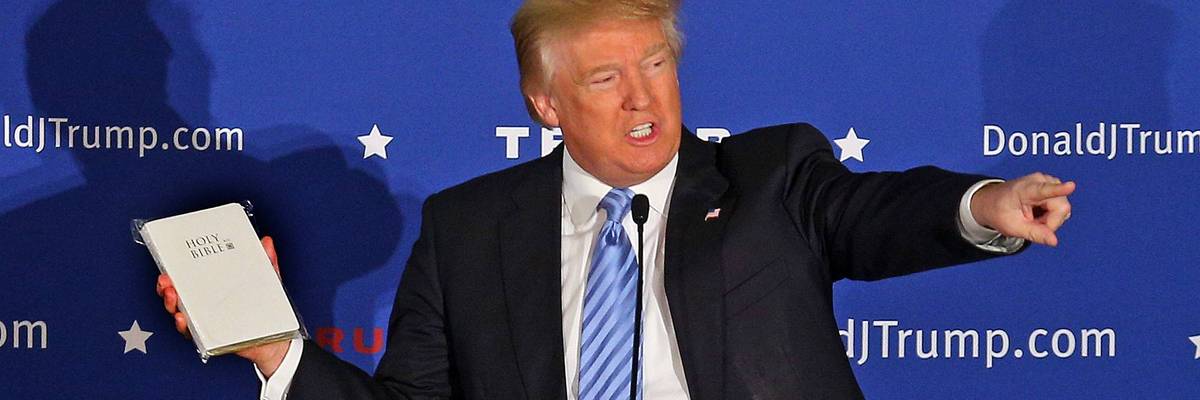 Donald Trump gestures with a Bible.