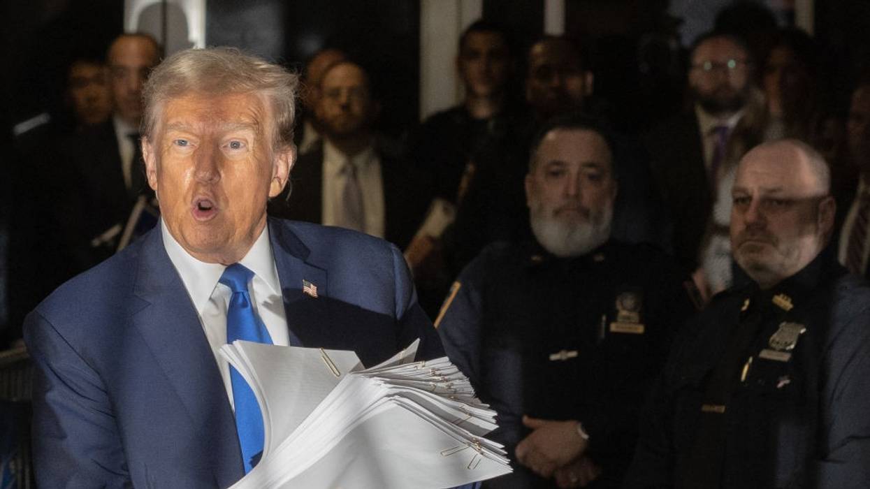 Donald Trump holds documents outside his New York trial