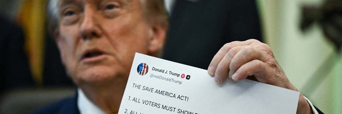 Donald Trump holds up a printout of one of his Truth Social posts