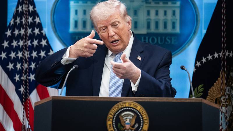 Donald Trump mimics firing a gun during a White House press conference
