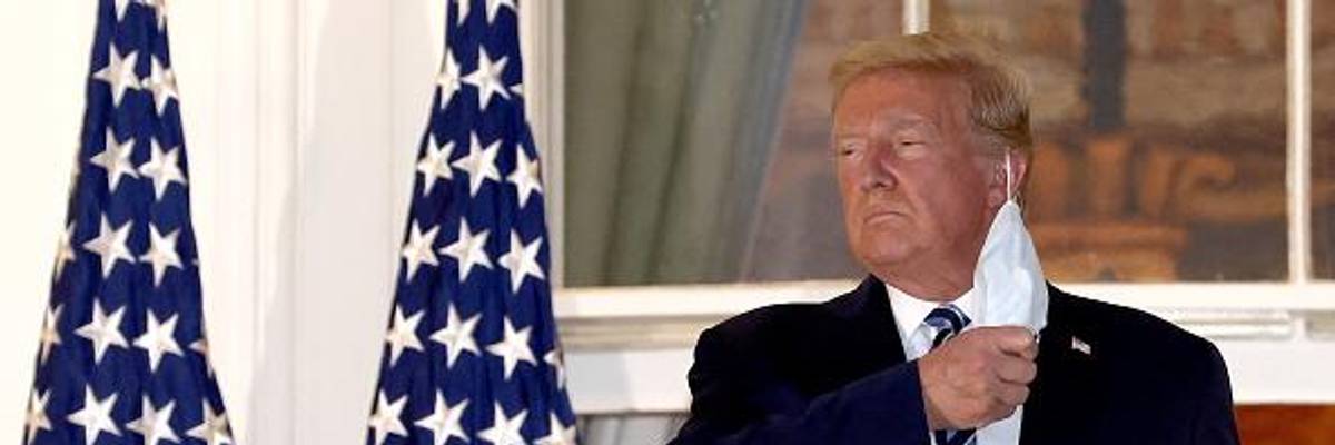 Donald Trump removes his mask on October 5, 2020, upon return to the White House from Walter Reed National Military Medical Center, where he had been hospitalized after contracting Covid-19.