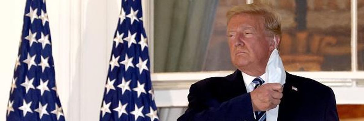 Donald Trump removes his mask on October 5, 2020, upon return to the White House from Walter Reed National Military Medical Center, where he had been hospitalized after contracting Covid-19.