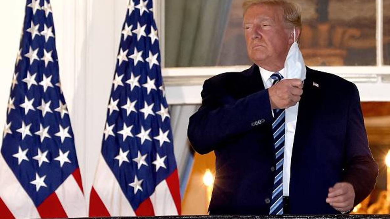 Donald Trump removes his mask on October 5, 2020, upon return to the White House from Walter Reed National Military Medical Center, where he had been hospitalized after contracting Covid-19.