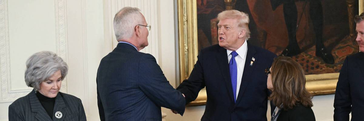 Donald Trump shakes hands with ExxonMobil CEO Darren Woods.