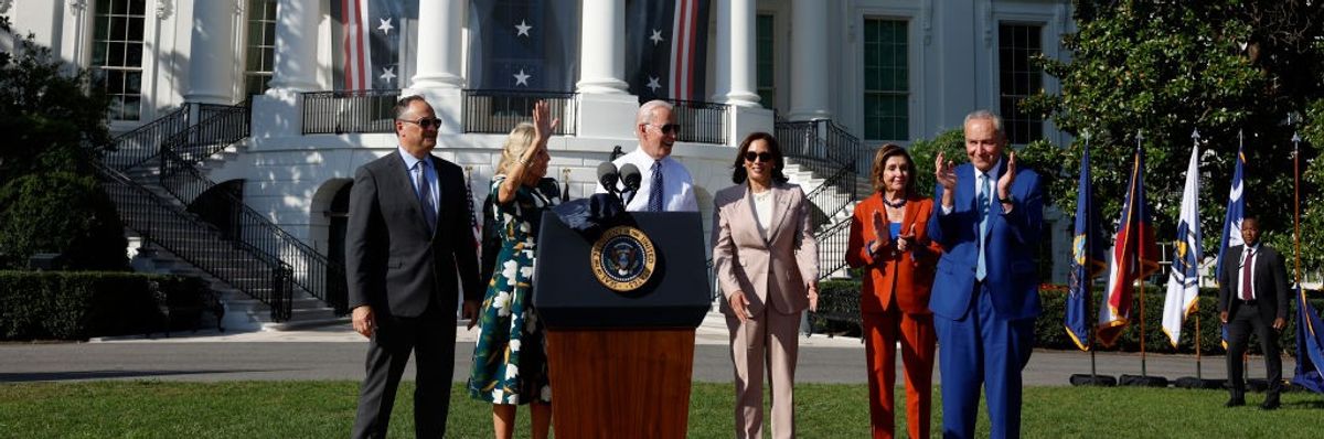 Doug Emhoff, Jill Biden, Joe Biden, Kamala Harris, Nancy Pelosi, and Chuck Schumer stand on the White House lawn.