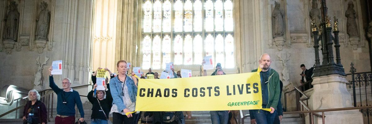 Dozens of climate and energy justice campaigners call for a stronger windfall profits tax to fund home insulation and clean energy production from inside the U.K. Parliament in London on October 24, 2022.