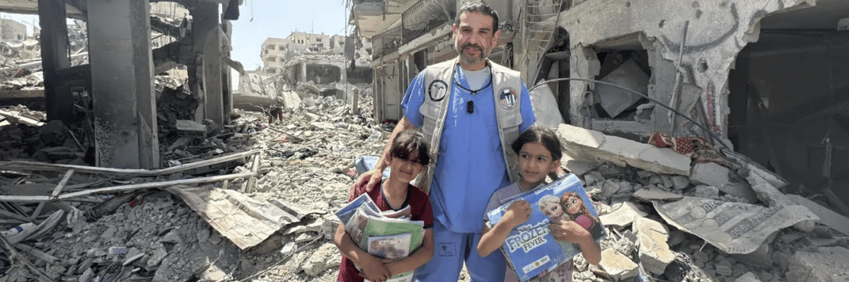 Dr. Adam Hamawy poses for a photo with two Palestinian children in obliterated Gaza