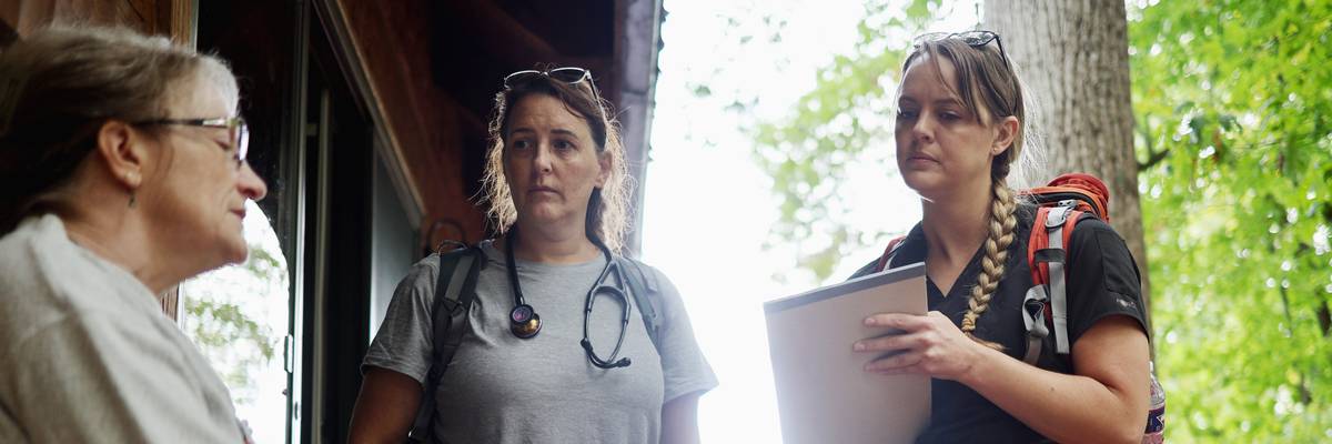 Dr. Khristina Meissner and nurse practitioner Jen Felter, both volunteers, check on a woman after delivering her medications