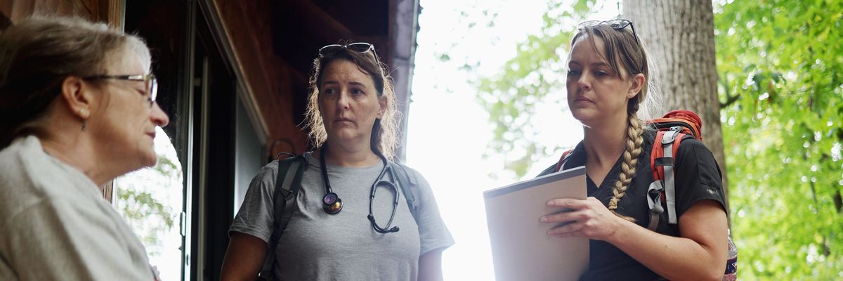 Dr. Khristina Meissner and nurse practitioner Jen Felter, both volunteers, check on a woman after delivering her medications