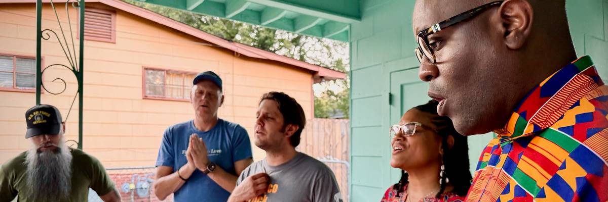 Dr. Michael W. Waters and members of Vote Common Good pray outside the home of Medgar Evers.