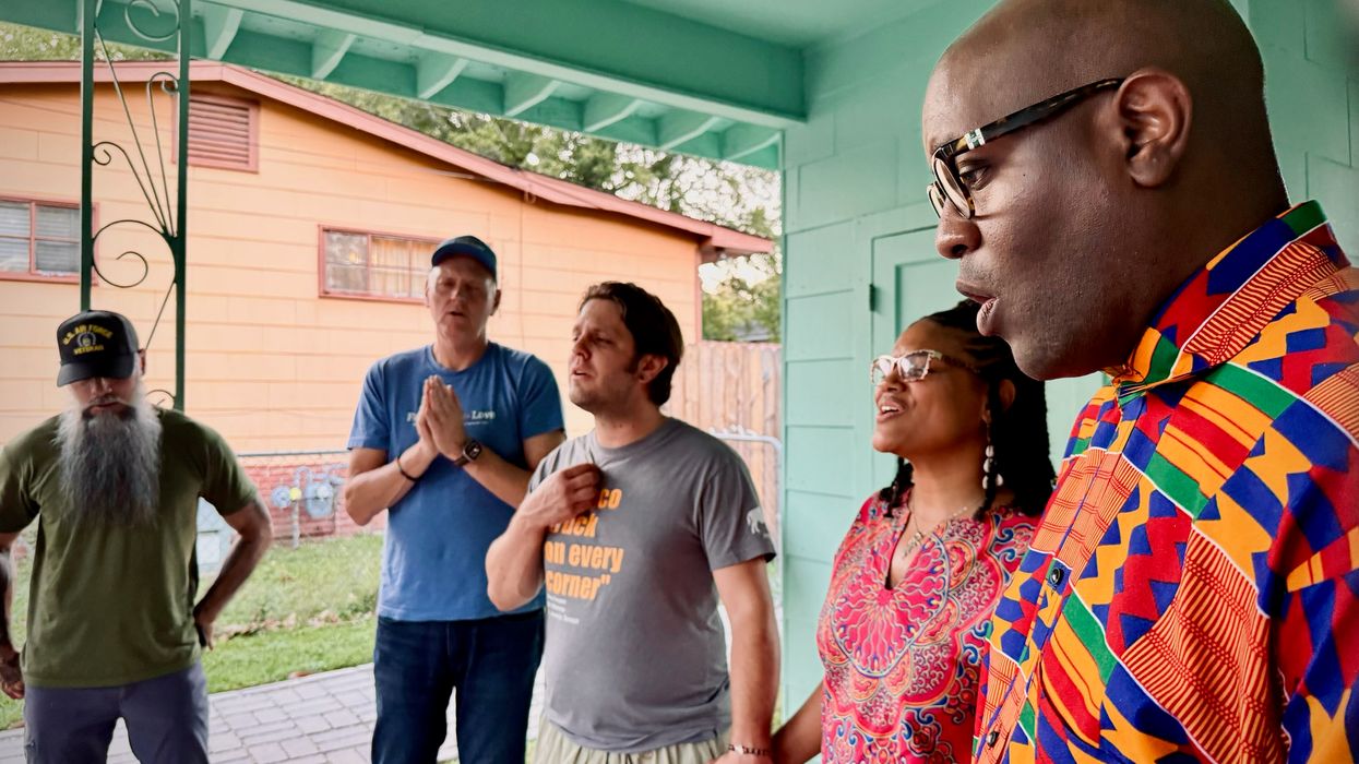 Dr. Michael W. Waters and members of Vote Common Good pray outside the home of Medgar Evers.