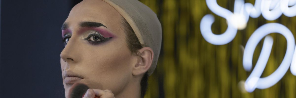 Drag performer applying makeup.